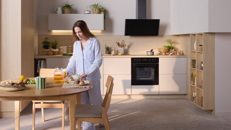 Cuisine grise avec plans de travail en bois, îlot central, touches noires et ambiance chaleureuse